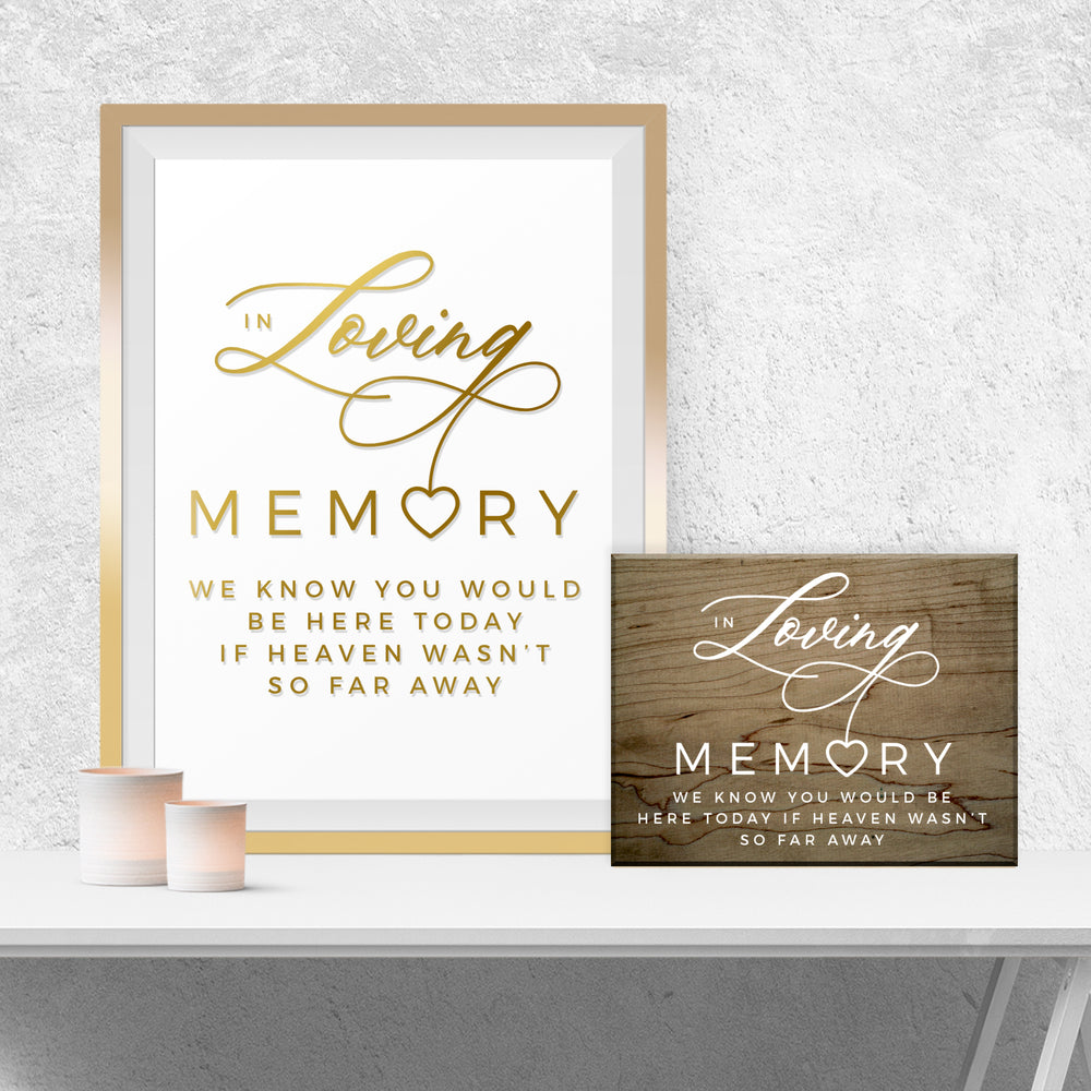 a framed sign with the text "In Loving Memory" and a smaller wooden sign with the same text, both placed on a white shelf against a white wall.