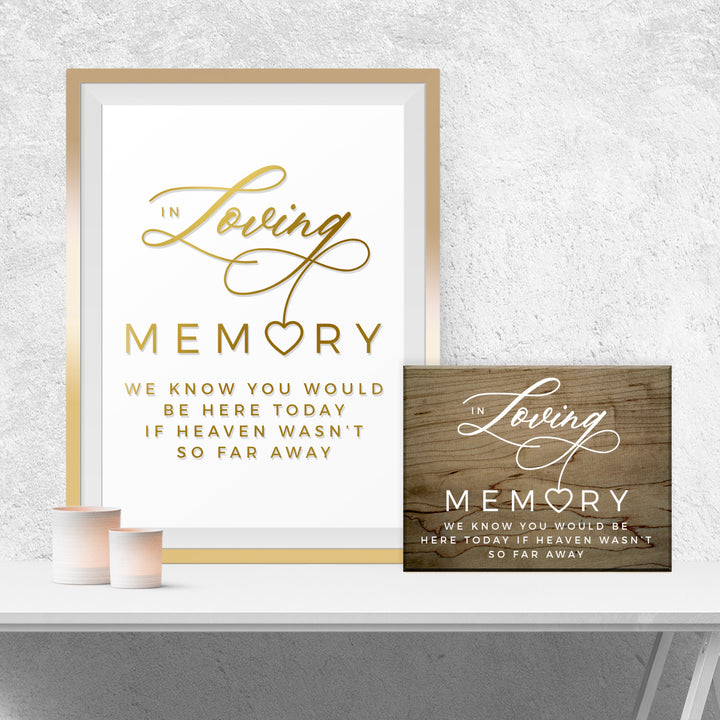a framed sign with the text "In Loving Memory" and a smaller wooden sign with the same text, both placed on a white shelf against a white wall.