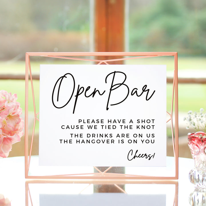 a sign that reads "Open Bar" with a humorous message about the drinks being on the hangover.