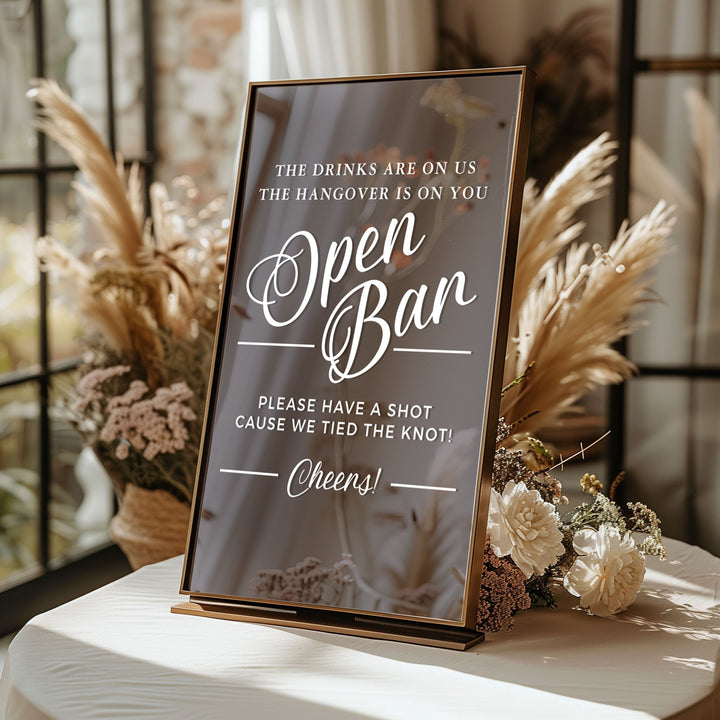 a sign that reads "Open Bar" with a humorous message about the hangover.