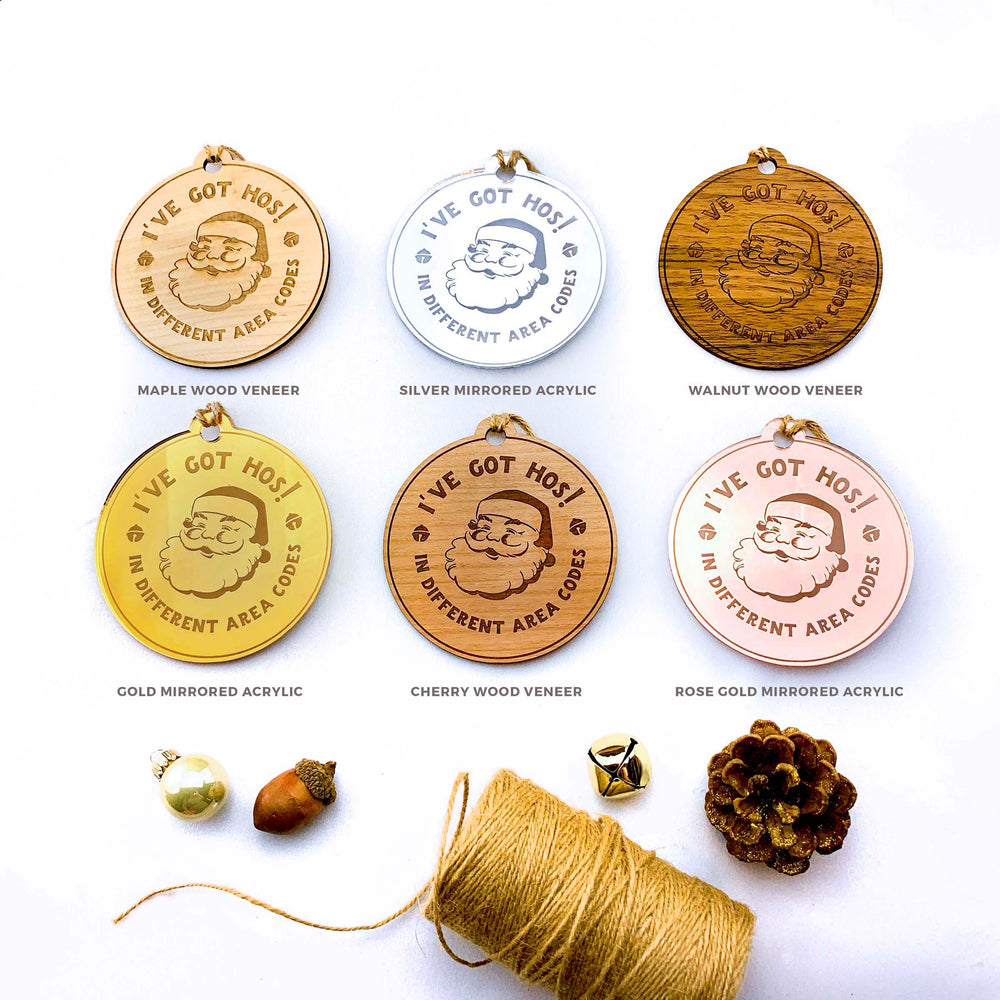 six circular ornaments with Santa Claus designs, each in a different color, arranged on a white background.