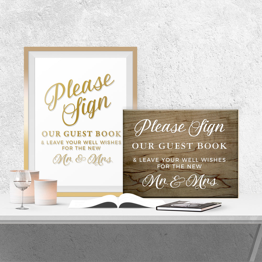 a sign that reads "Please Sign Our Guest Book & Leave Your Well Wishes for the New Mr & Mrs." along with a wooden sign that says "Please Sign Our Guest Book & Leave Your Well Wishes for the New Mr & Mrs." The signs are placed on a white table, with a book and a candle in the background.