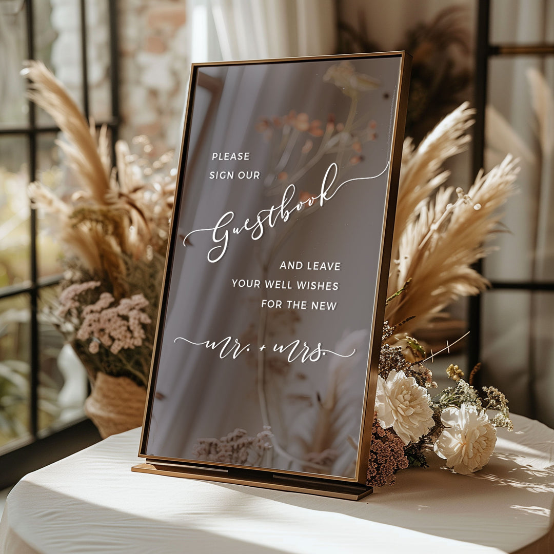 a guestbook sign with a message for guests at a wedding reception.