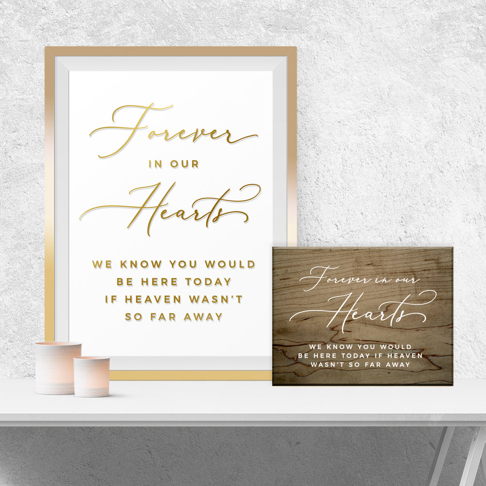 a framed sign with the text "Forever in our hearts" and a smaller wooden sign with the same text, both placed on a white shelf against a white wall.