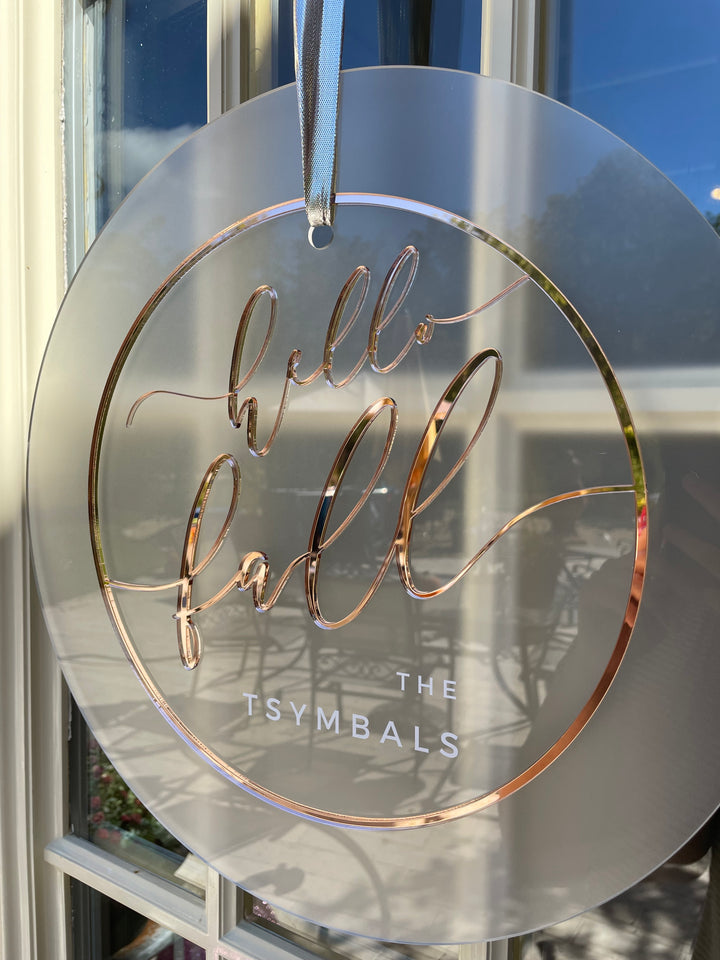 a circular sign with a metallic, cursive-style design.